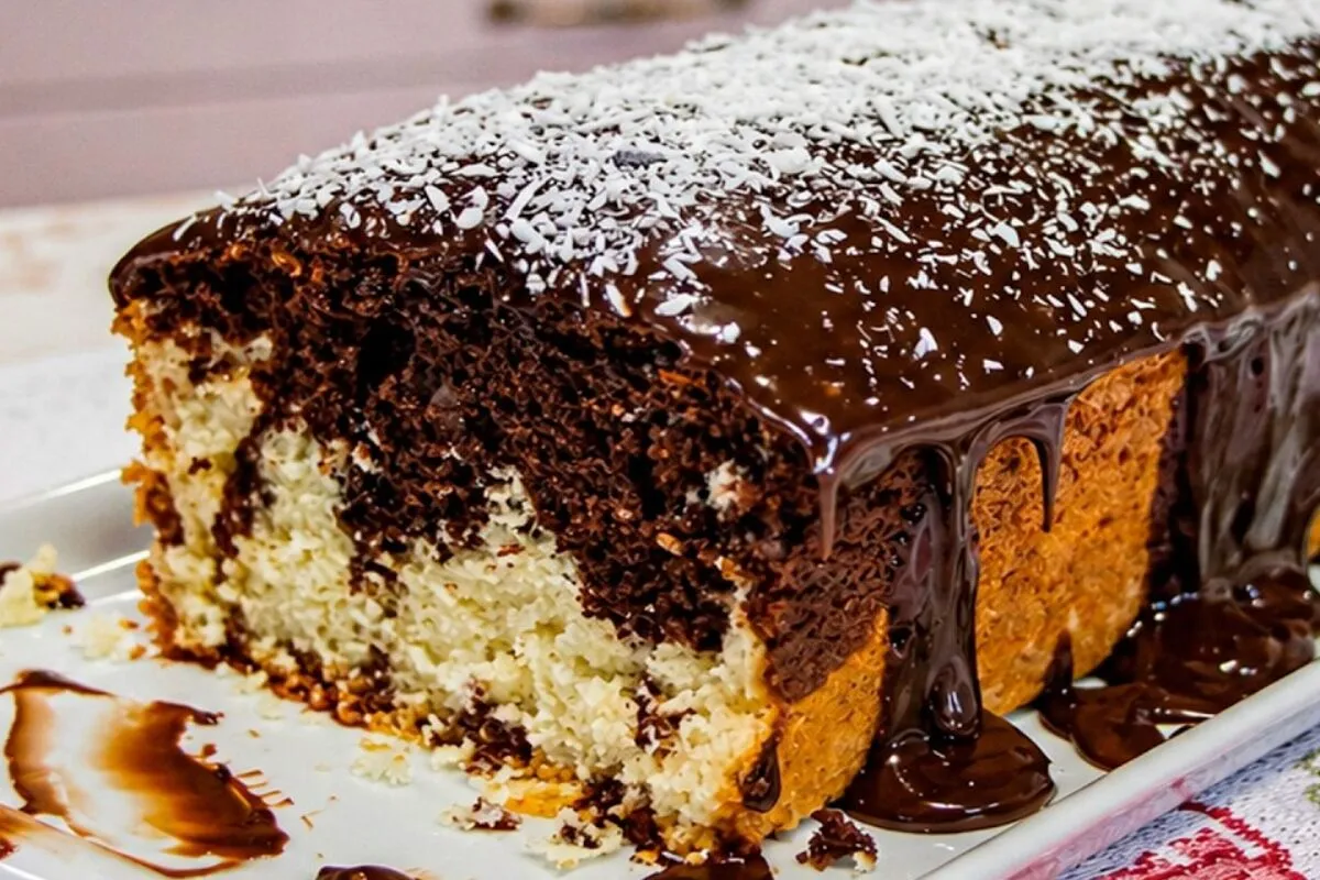 Bolo mesclado de coco com chocolate e cobertura cremosa que