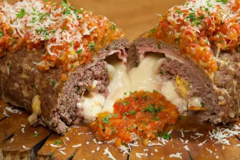 Rocambole de carne moida recheado com bastante queijo e pres